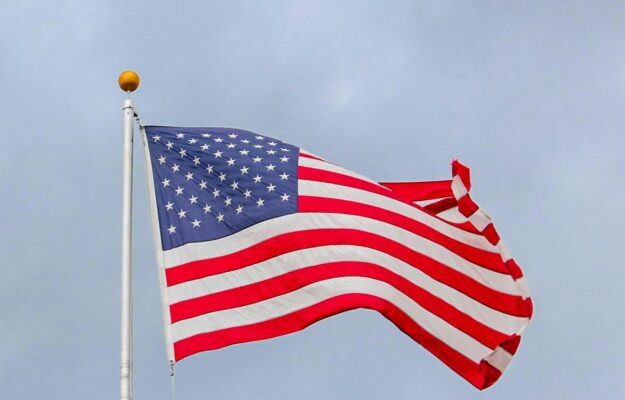 usa flag waving on white metal pole