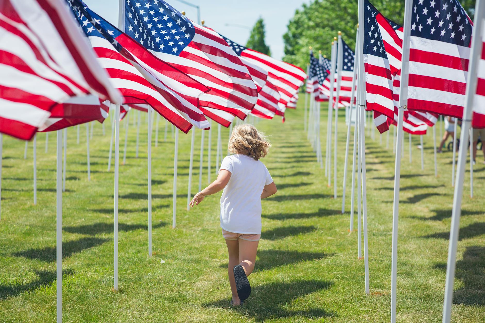 child running among american flags - what is freedom?