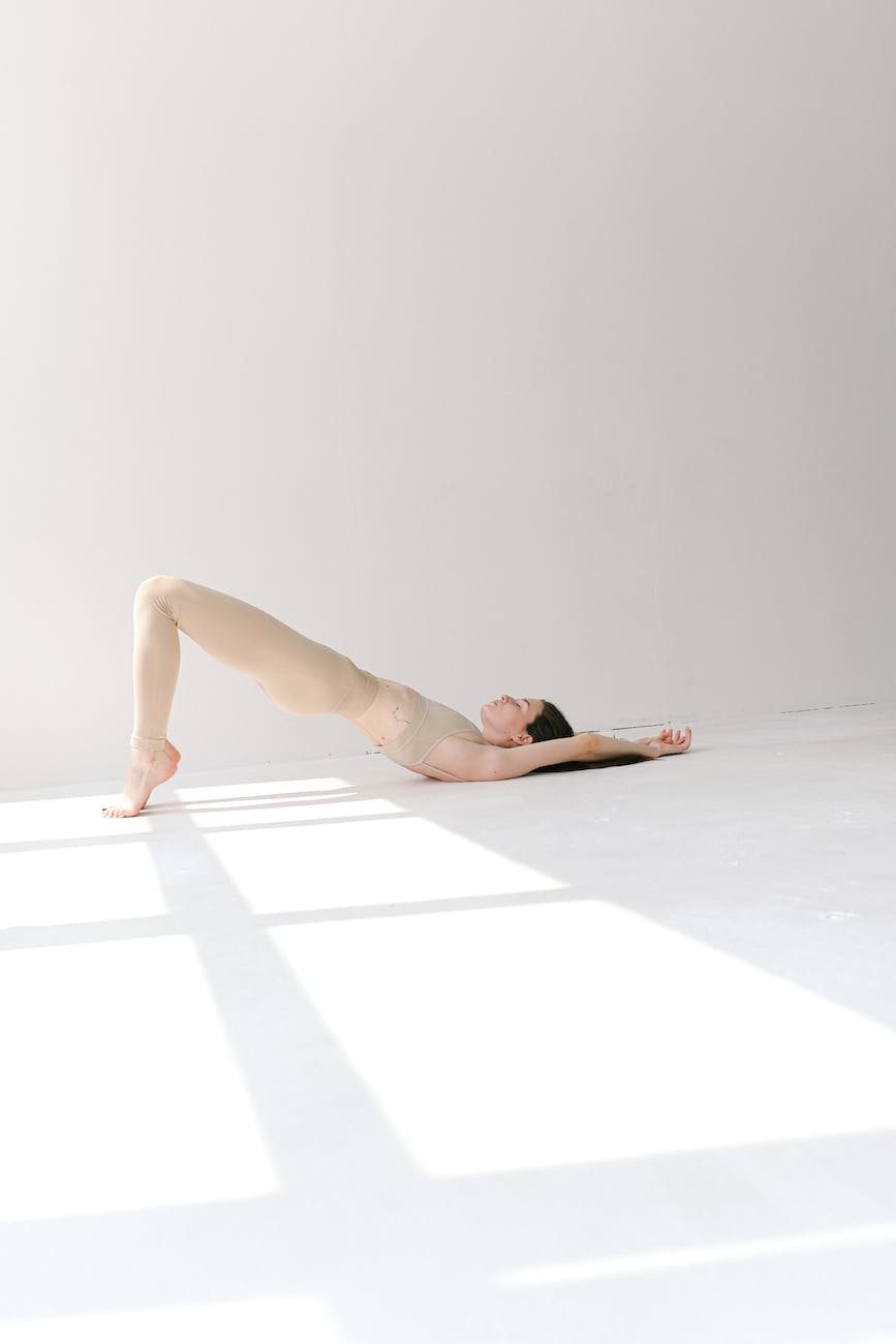 slim woman in bridge pose in studio