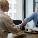 ethnic businessman shaking hand of applicant in office